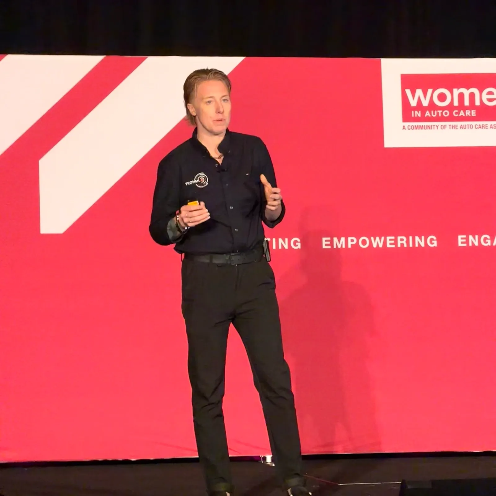 Lauren McCullough speaking on stage at a Women in Auto Care event